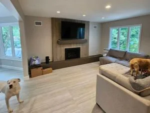 Living room with light gray painted walls, white trim, and a vertical wood-paneled fireplace wall with recessed fireplace