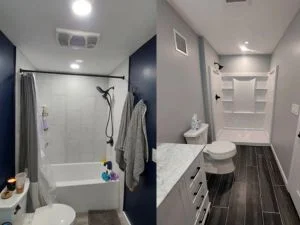 Bathroom with navy accent walls, gray painted walls, white tub-shower tile, and dark wood-look plank flooring
